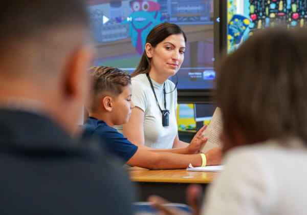 Teacher wearing hearing augmentation solution device in classroom